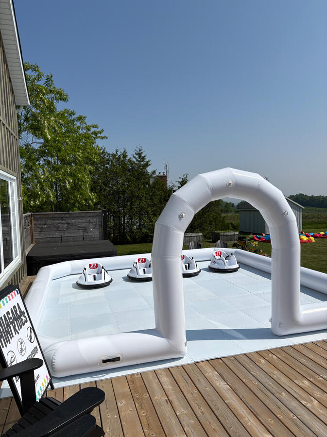 A clean, modern inflatable arena setup. Outdoor white inflatable bumper car arena set up on deck for kids party in Niagara.