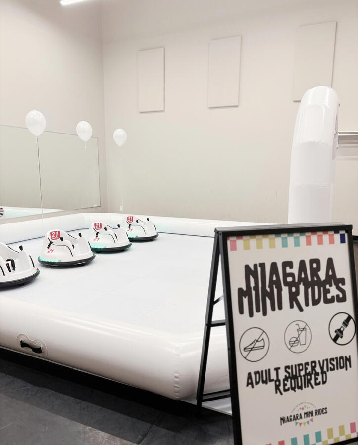 Indoor bumper car setup for winter birthdays or indoor venues. All-white bumper car arena with four cars.